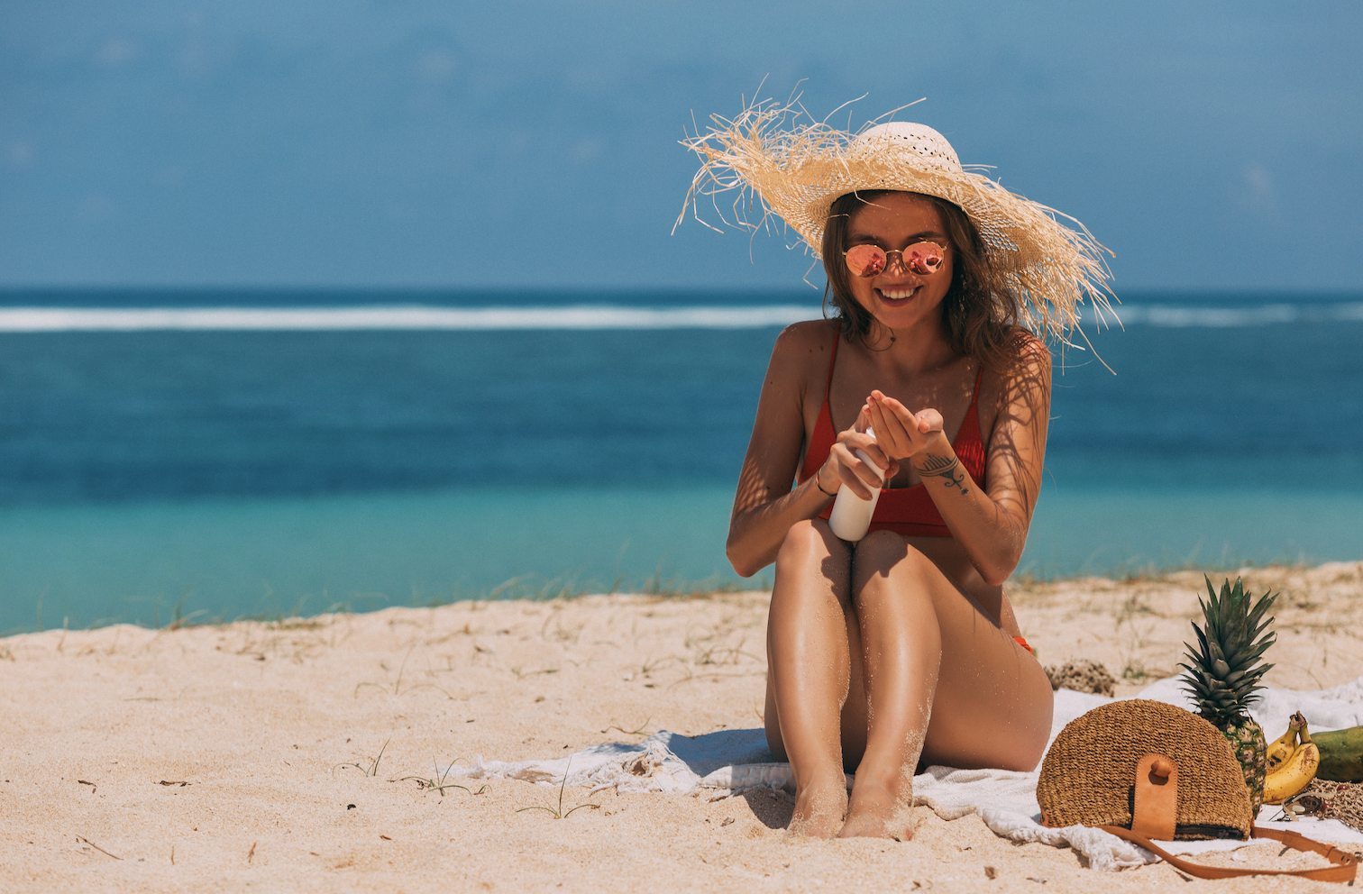 Girl applying sunscreen at the beach