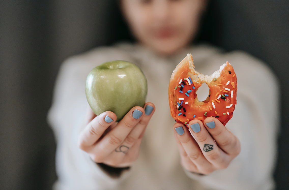 Girl chooses between apple or donut