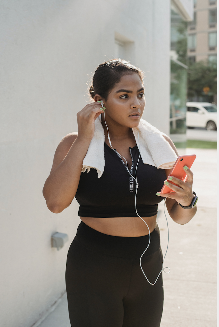 Woman exercising using phone and earphones